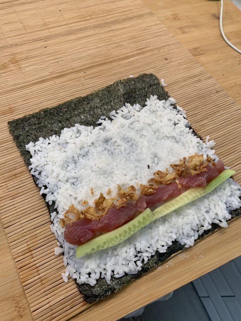 Sushi casero con salmón, aguacate y queso crema preparado en casa.