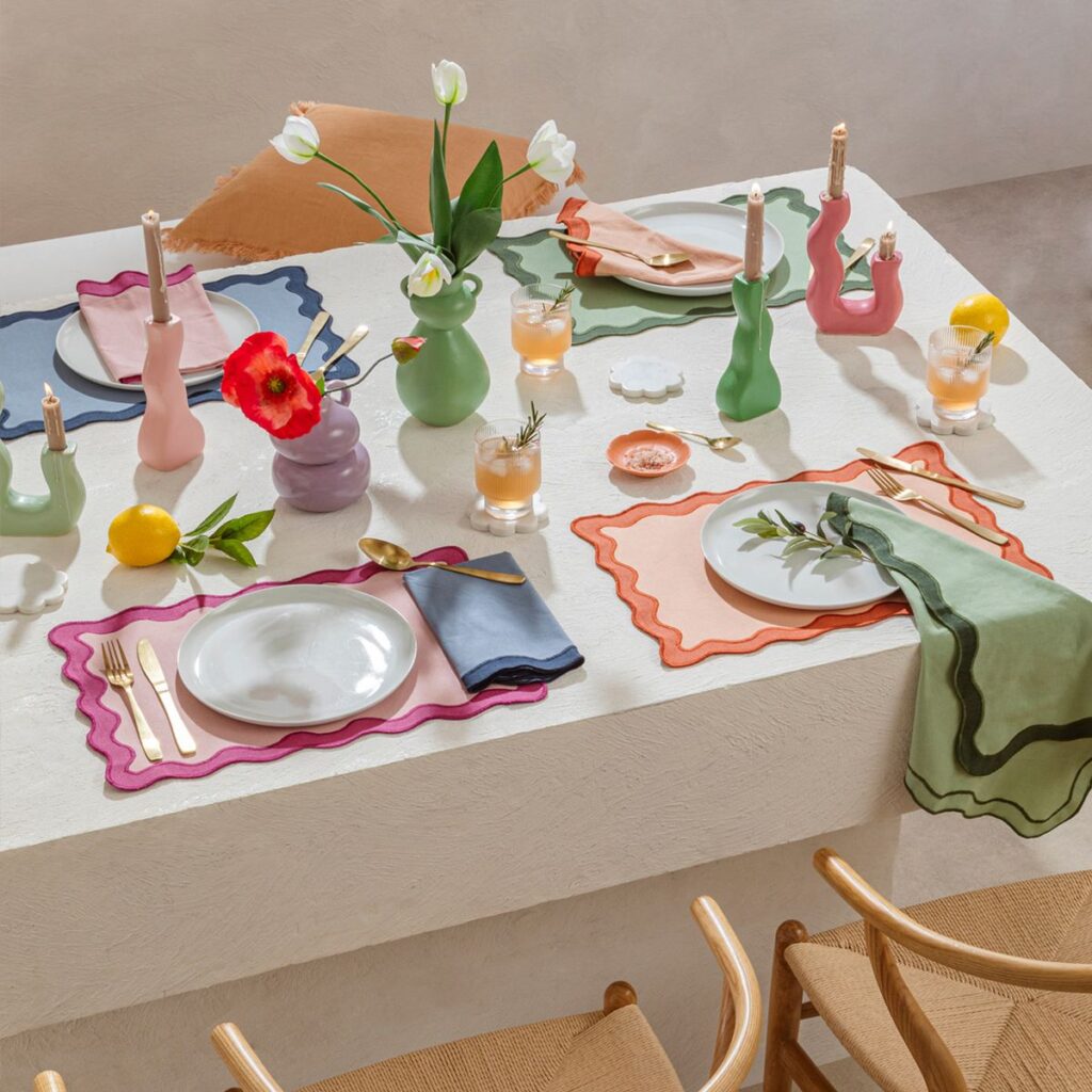 Mesa decorada con vajilla artesanal de cerámica reciclada, servilletas de lino y centro natural con flores secas.